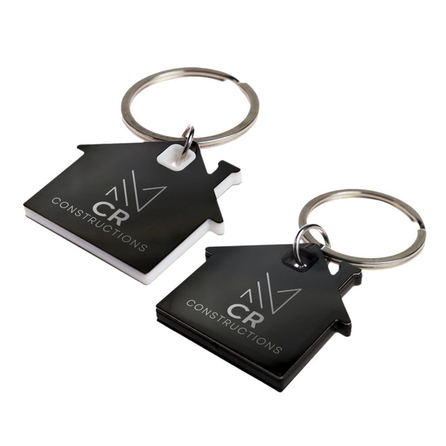Two house-shaped keytags in black and white, each featuring a logo and a metal keyring attachment. Two house-shaped keytags in black and white, each featuring a logo and a metal keyring attachment.