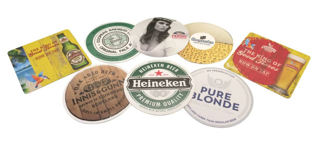 A collection of circular cardboard drink coasters in various designs and colours, featuring different beer brands and logos. A collection of circular cardboard drink coasters in various designs and colours, featuring different beer brands and logos.