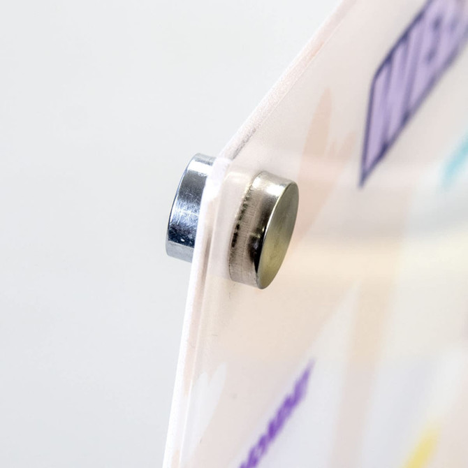 A magnetic fridge planner with a white background and colourful designs, featuring a visible silver magnet.