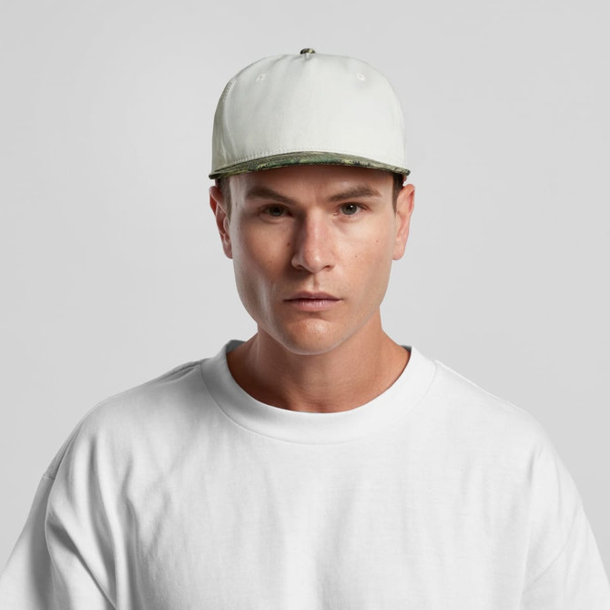 A man wearing a two-tone camouflage cap in white and green, paired with a plain white T-shirt.