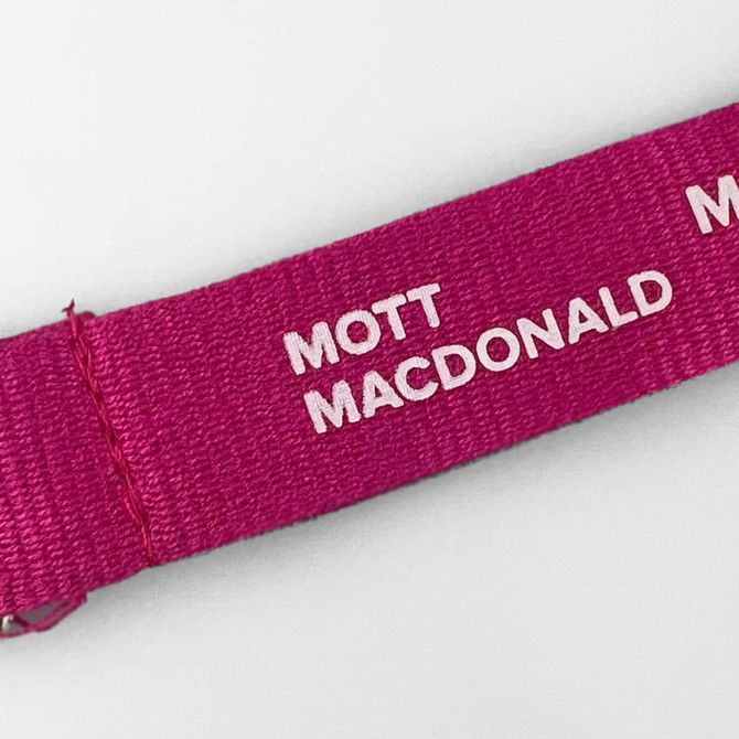 A pink cotton lanyard featuring white text. The lanyard has a branding logo.