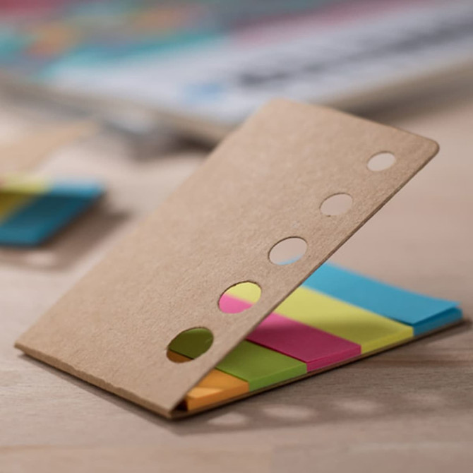 A set of colourful sticky notes in a cardboard holder, featuring pink, yellow, blue, and orange notes.