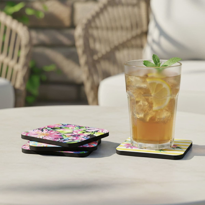 A drink bottle sits on a vibrant floral 5mm neoprene coaster, with a few more coasters stacked beside it.