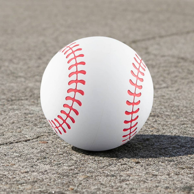 A high bounce baseball in white with red stitching, resting on a textured grey surface. It has a logo on it.