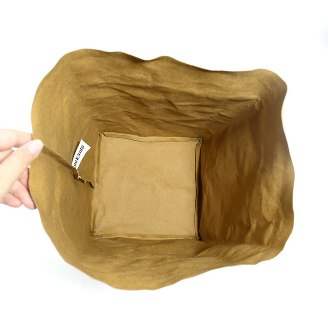 A hand holds an extra large, brown kraft paper storage bag with a simple design and a visible logo inside.