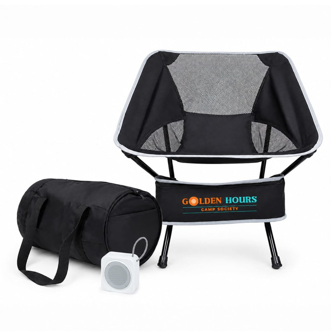 A portable camping chair in black fabric with a mesh backrest, accompanied by a carrying bag and a small speaker.