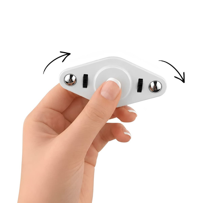 A hand holding a white Vibro Fidget Spinner with silver accents, featuring control buttons on each side.