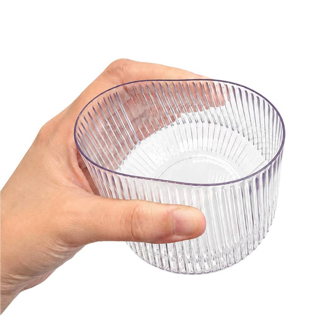 A clear, ribbed tumbler held in a hand, featuring a stylish design and a transparent appearance.