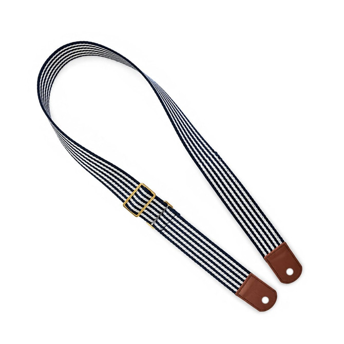 A striped shoulder strap featuring navy blue and white lines with brown leather ends and a gold buckle.