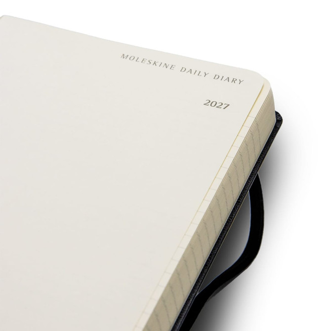 A Moleskine 2027 Daily Planner with a black cover and blank pages, featuring a logo on the front.