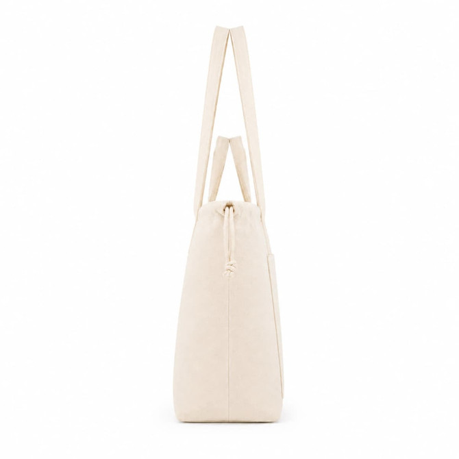 A cream tote bag with long handles and a drawstring closure at the top, featuring a subtle logo.