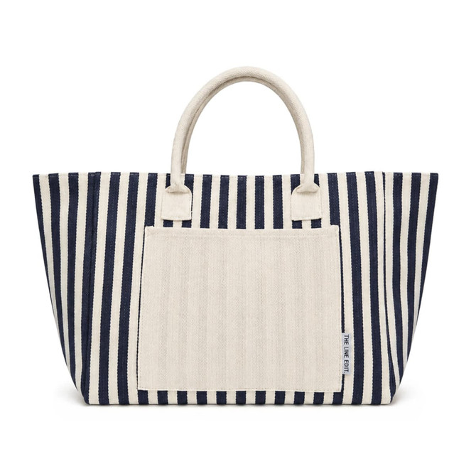 A striped tote bag in navy and cream with top handles and a front pocket. Features a logo on the side.