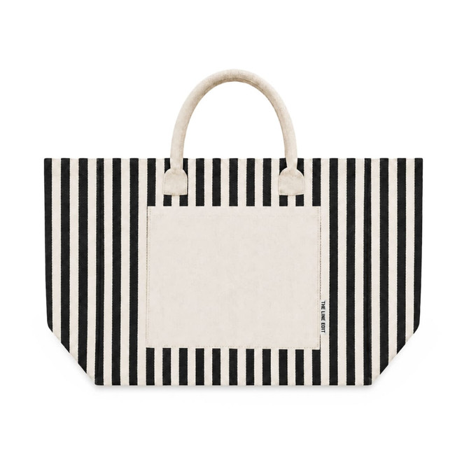 A striped tote bag in black and cream with a large front pocket and two handles. It features a logo branding.