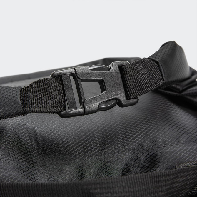 A close-up of a black dry bag featuring a sturdy fastening buckle and textured interior. The bag has a logo.