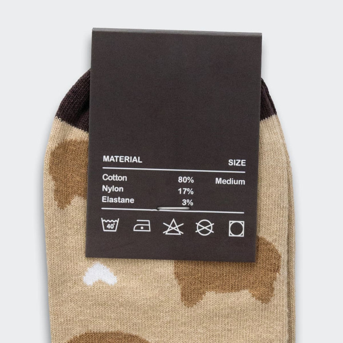 A pair of beige ankle socks with brown and white patterns, featuring a tag with material and size details.