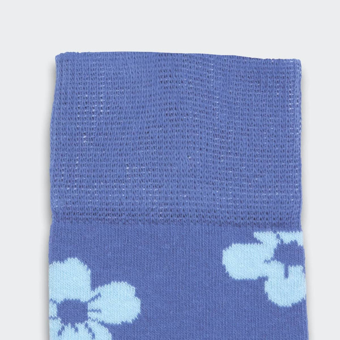 A pair of pixel knitted knee-high socks in blue with light blue floral patterns. Features a knitted texture at the top.