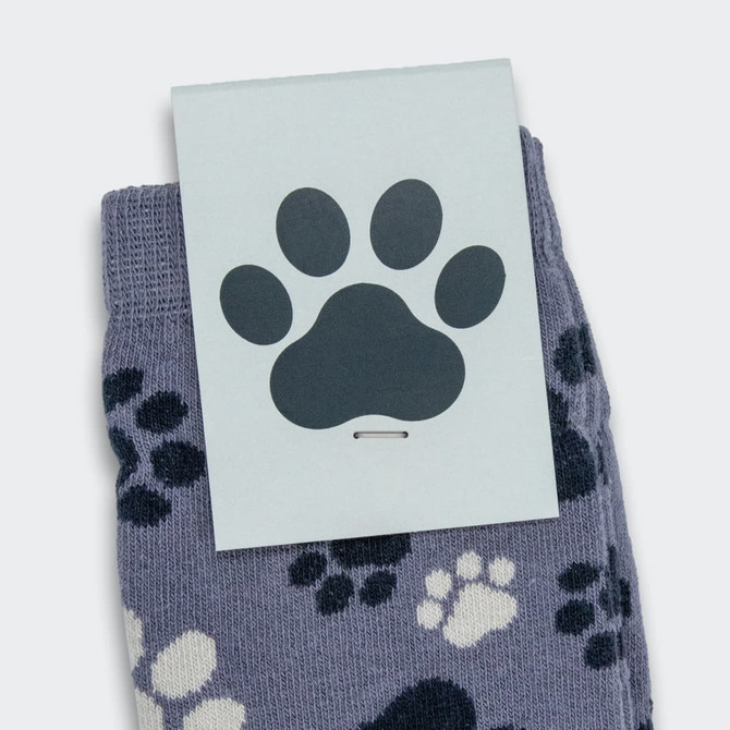 Jolly knitted kids socks in grey with a playful paw print pattern, featuring a branded tag.