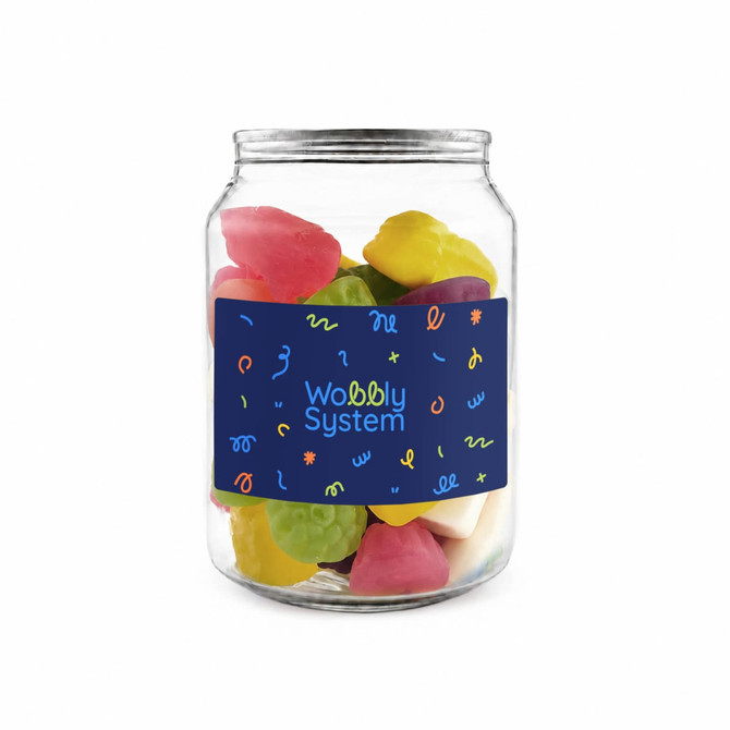 A glass jar filled with colourful gummy candies in various shapes and sizes, featuring a decorative label.