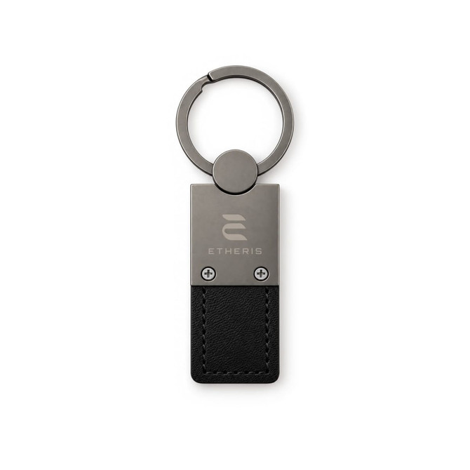 A silver keytag with a black leather attachment and a logo on the metal part.