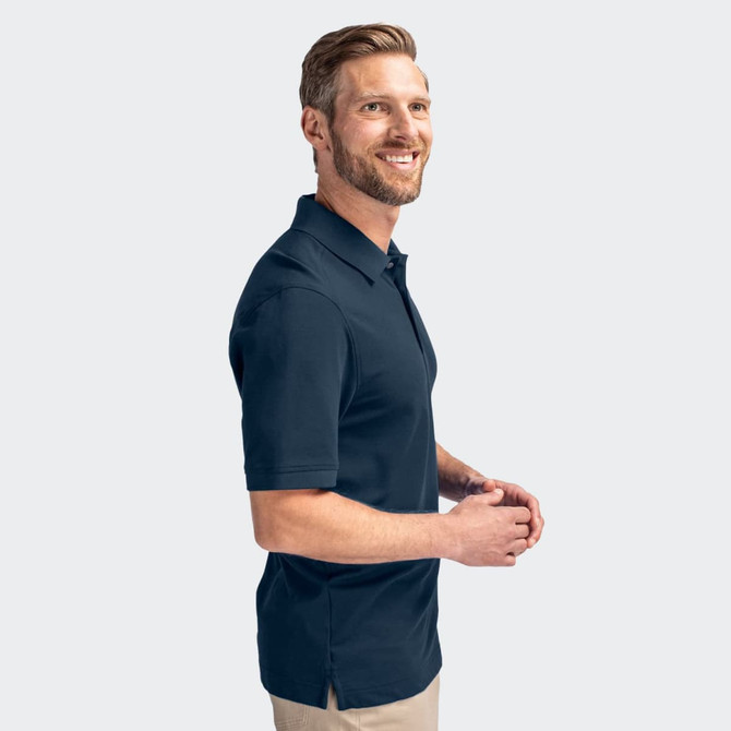 A men's polo shirt in navy blue, featuring a logo and a classic collar design, worn by a smiling man.