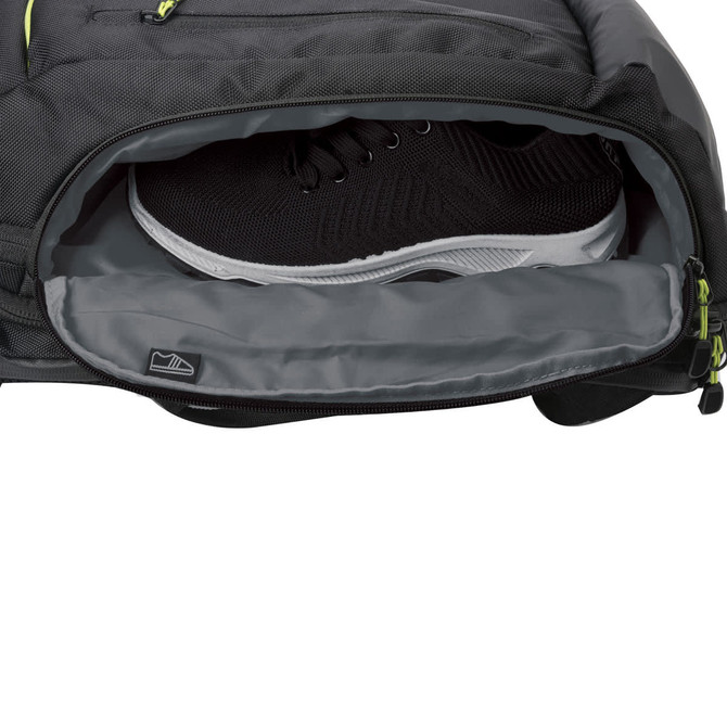 A black backpack with a separate compartment holding a pair of black shoes, featuring a small logo.
