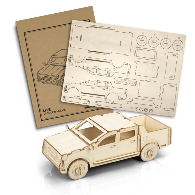 A wooden model of a UTE in natural wood colour, accompanied by a detailed assembly sheet. It features a logo.