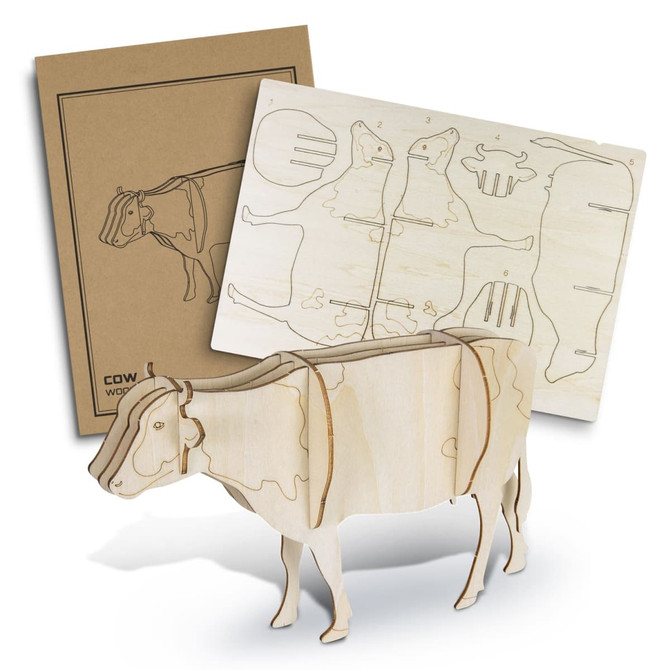 A wooden model of a cow in a natural finish, accompanied by a cardboard backing with cut-out designs.