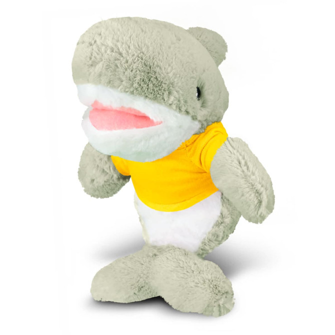 A grey shark plush toy wearing a yellow shirt, featuring a wide mouth and friendly expression.