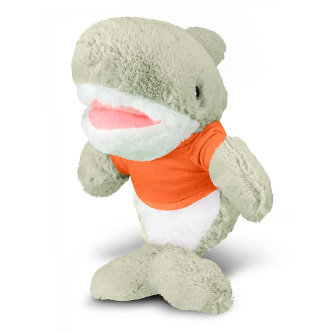 A grey shark plush toy wearing an orange shirt, standing upright with a smiling mouth. It has a soft and cuddly appearance.