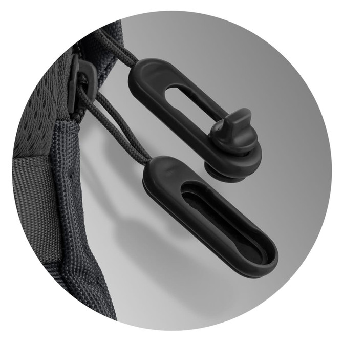 Close-up of black toggles on a green backpack, featuring adjustable cord locks for securing contents.