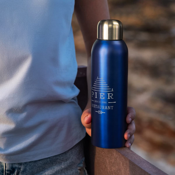 A drink bottle in a deep blue colour with a metallic gold lid, featuring a logo.
