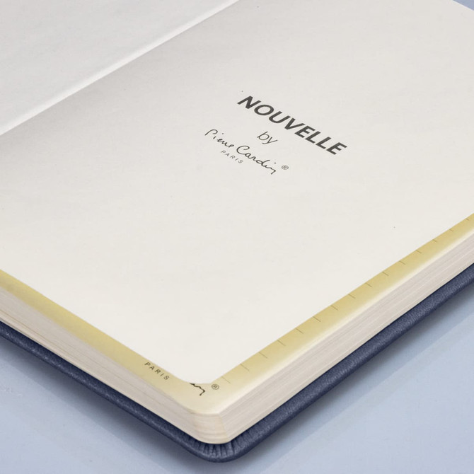 A navy blue notebook with blank pages, featuring a simple interior design and a logo on the inside cover.