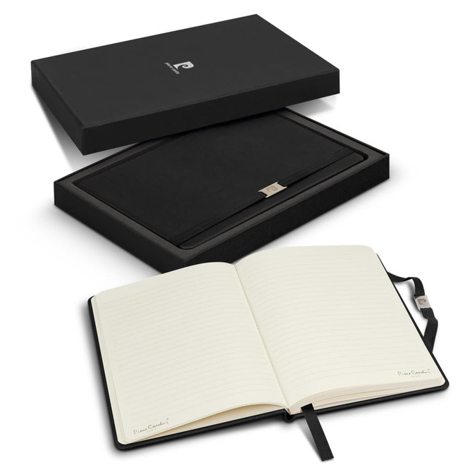 A black gift box containing a sleek notebook with lined pages, featuring a logo and a ribbon bookmark.