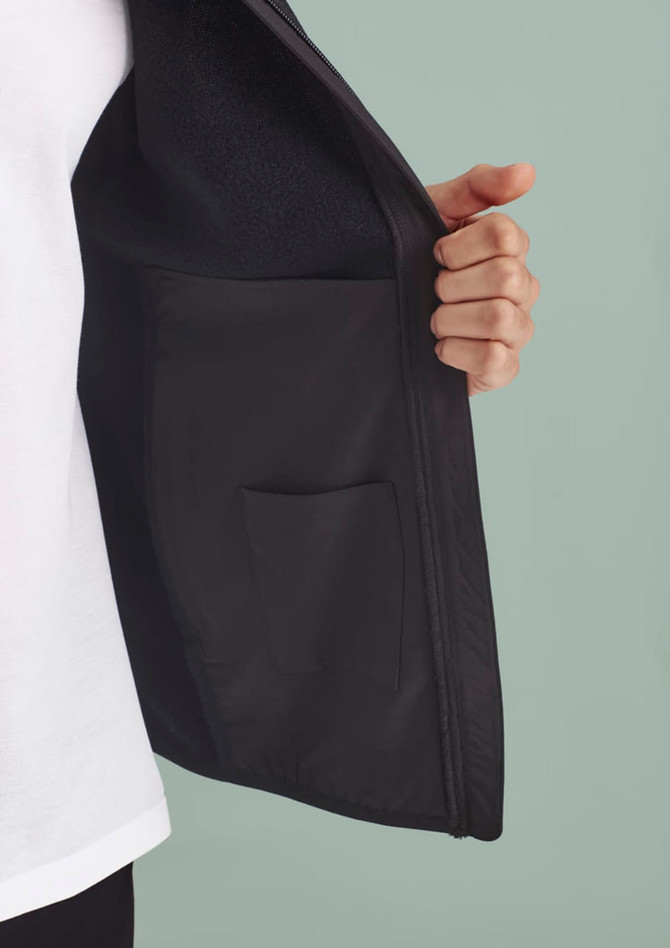 A black vest is held open, displaying an interior pocket. The fabric appears smooth and suitable for workwear.