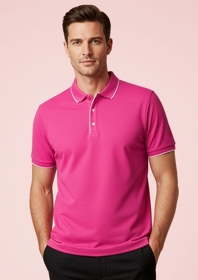 A pink short sleeve polo shirt with contrasting trim and a logo. Styled on a model against a pink background.