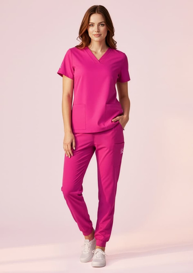 A model wearing bright pink jogger scrub pants paired with a matching top, featuring a logo.