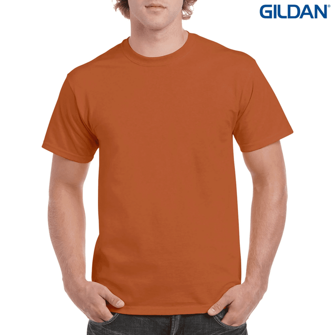 An orange heavy cotton adult T-shirt on a model, featuring a logo in the top corner.