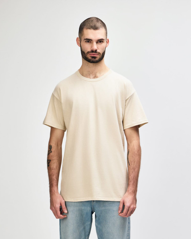 A beige Gildan Softstyle adult t-shirt displayed on a male model, featuring short sleeves and a classic fit.