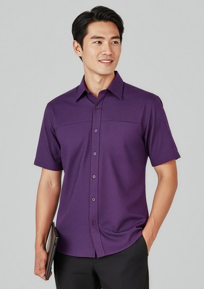 A plain purple short sleeve button-up shirt featuring a subtle logo, paired with black trousers.