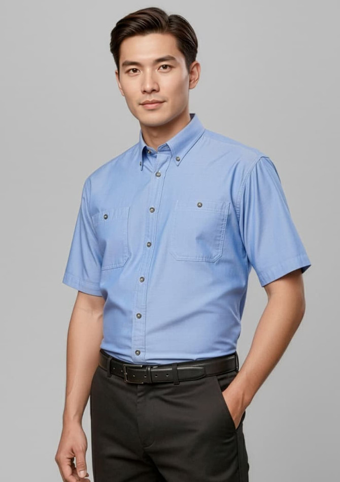 A light blue short sleeve button-up shirt featuring two front pockets and a logo.