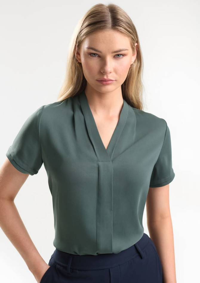 A short sleeve button-up shirt in a muted green colour, featuring a v-neck design and a subtle logo.