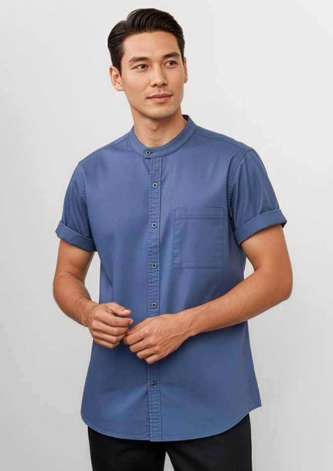 A blue short sleeve chef shirt with a mandarin collar and a chest pocket, featuring rolled sleeves and a button-up design.