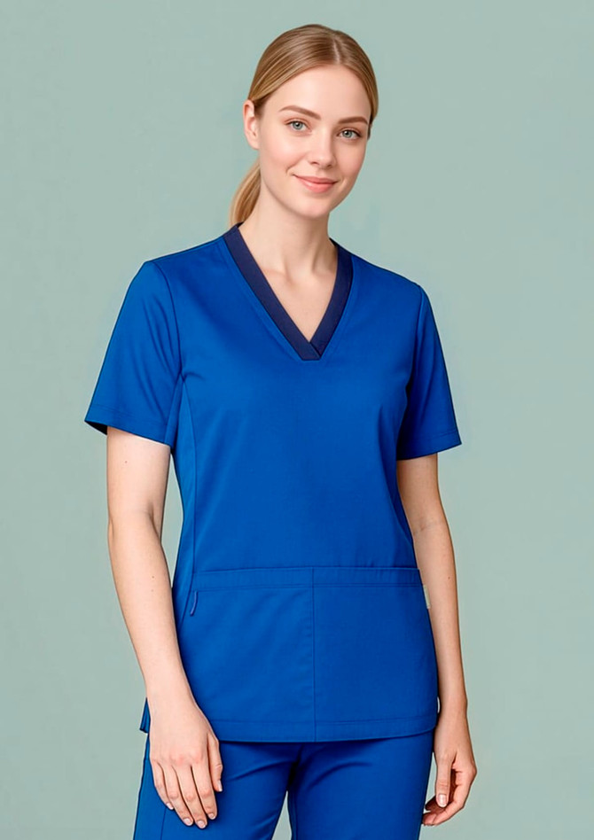 A woman wearing a blue scrub top featuring a V-neck and short sleeves, paired with matching scrub pants.