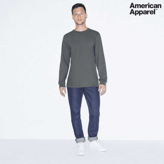 A long sleeve fine jersey t-shirt in dark grey, paired with jeans and white sneakers, featuring a logo.