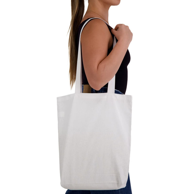 A white cotton long handle tote bag is held by a person, featuring straps and a simple design.