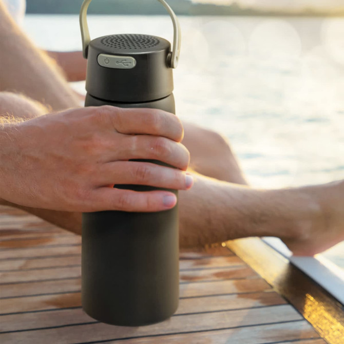 A drink bottle in matte black featuring a Bluetooth speaker on the lid and a carrying handle.
