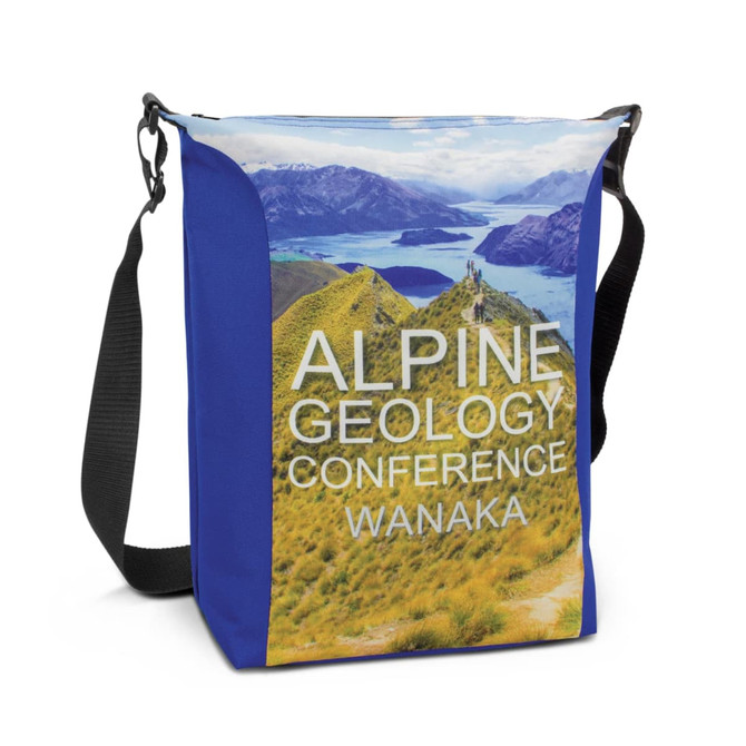 A conference cooler bag in blue with a scenic landscape print featuring mountains and lakes. It has an adjustable strap.