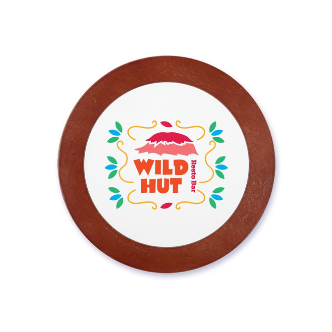 A circular coaster featuring a colourful design with the name "WILD HUT" and decorative elements. It has a wooden border.
