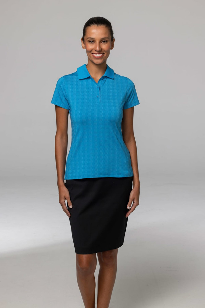 A woman models a bright blue polo shirt paired with a black skirt. The shirt features a logo.