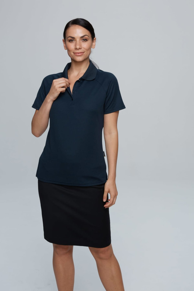 A navy polo shirt with a collar, displayed on a model paired with a black skirt. The shirt has a logo.